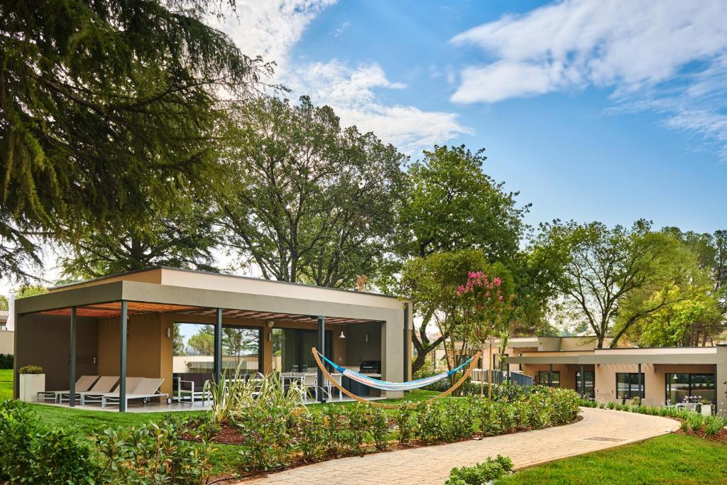 una casa con una hamaca delante en Villas Park Plava Laguna, en Poreč