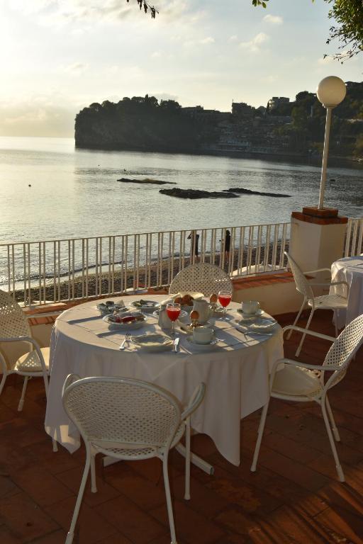 a table on a balcony with a view of the ocean at Hotel Lido Mediterranee in Taormina