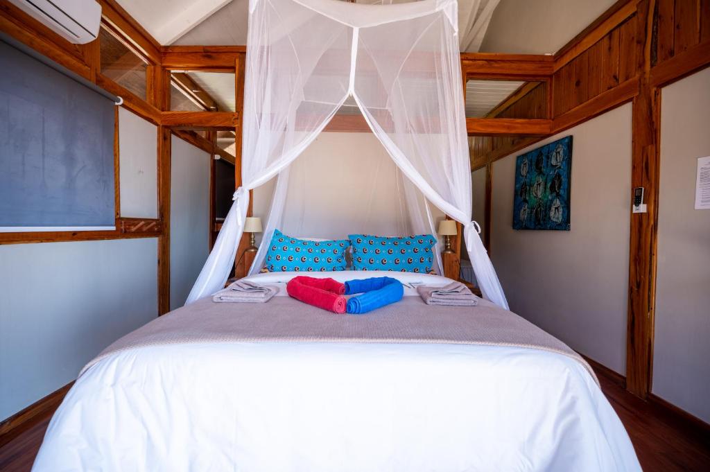 a bedroom with a white bed with a canopy at Aloha 22 in Ponta Mamoli