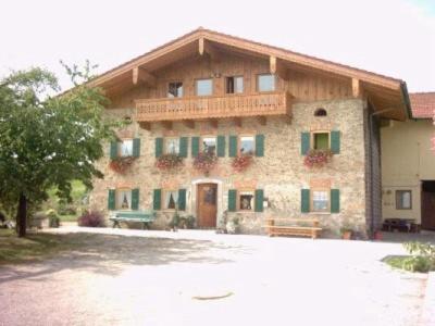 Un grand bâtiment en briques avec un balcon est disponible. dans l'établissement Lohnerhof, à Teisendorf