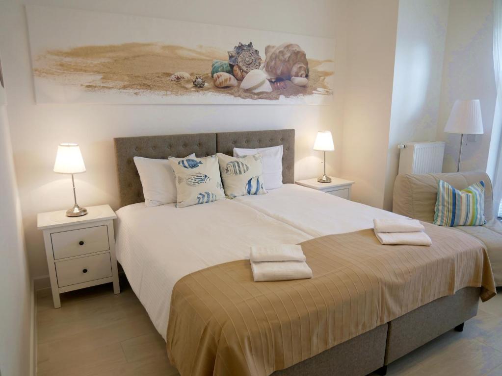 シフィノウイシチェにあるTrzy Wyspy Apartments - Aquamarinaのベッドルーム1室(大型ベッド1台、ランプ2つ、椅子付)