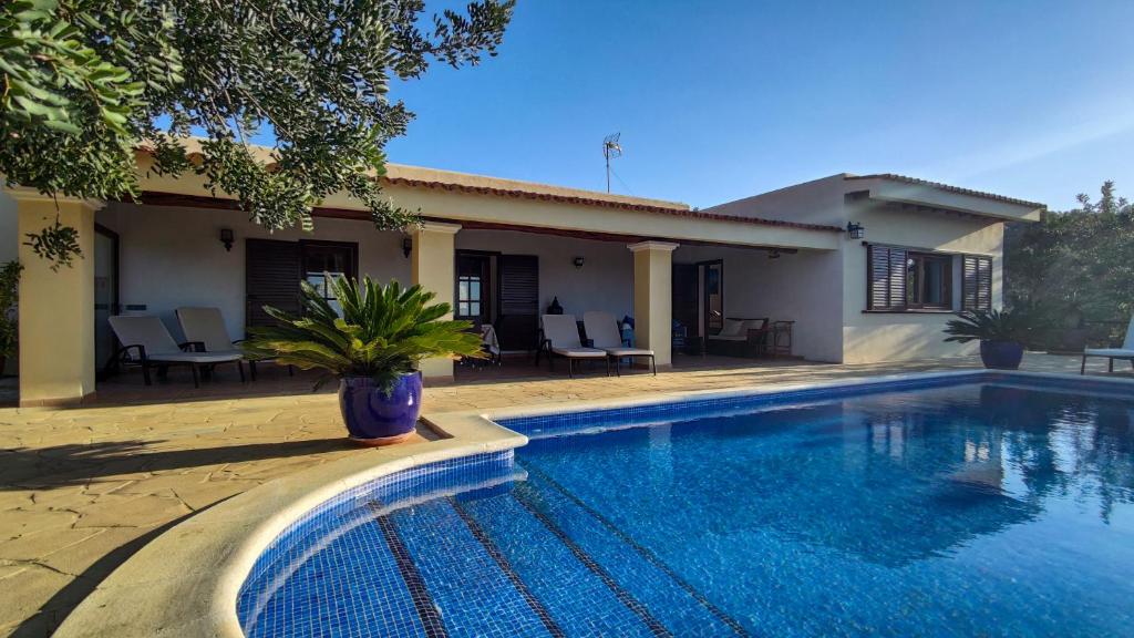 una villa con piscina di fronte a una casa di CASA SHERA a San Jose de sa Talaia