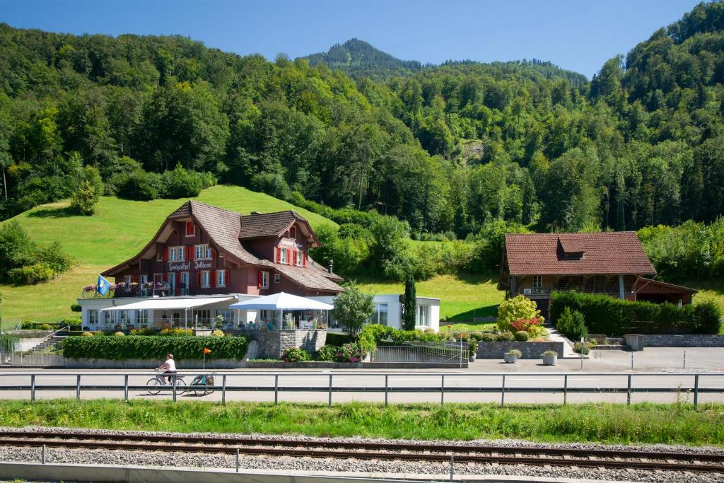 a person riding a bike in front of a house at Landgasthof Zollhaus in Sachseln