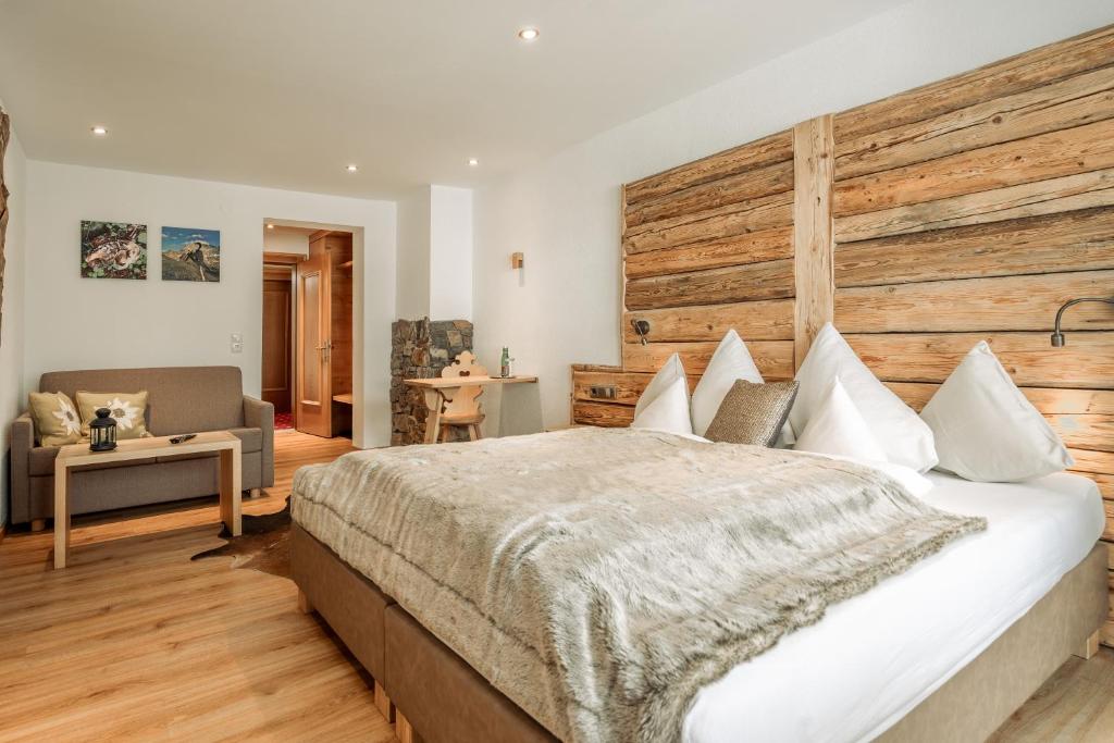 a bedroom with a large bed with a wooden headboard at Fortuna Apart Hotel B&B in Ischgl