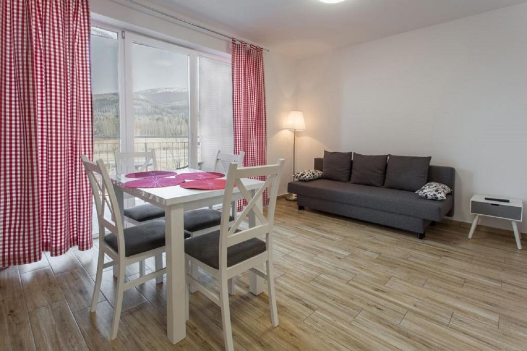 sala de estar con mesa, sillas y sofá en K2 Apartamenty en Karpacz