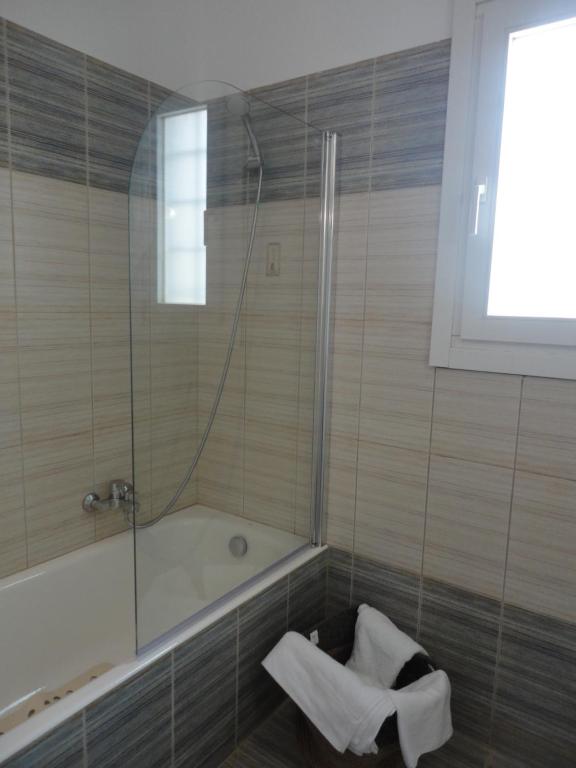 a bathroom with a bath tub and a shower at Monolithos Villas in Kipri