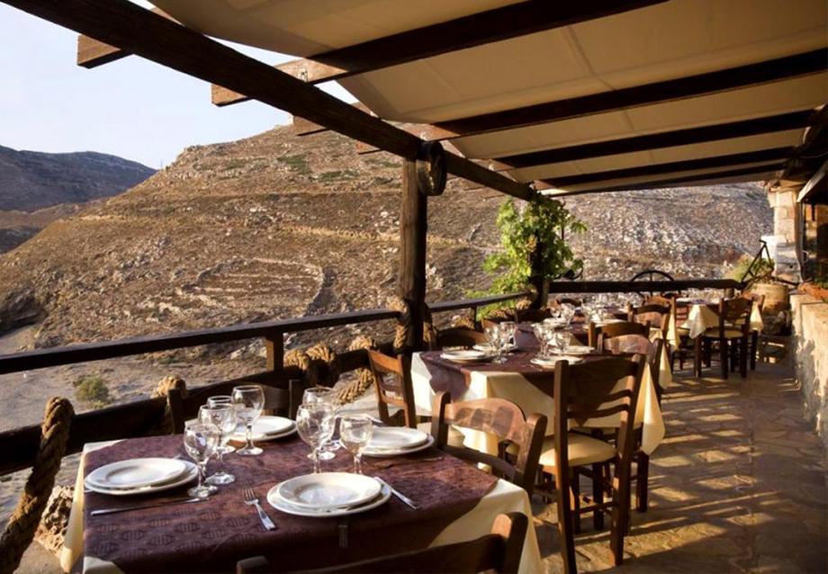 a restaurant with tables and chairs with a view of a mountain at Marmari Paradise Resort Hotel in Marmari