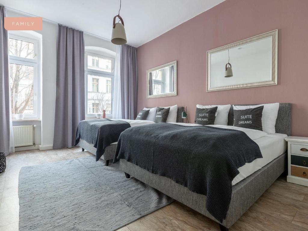 two beds in a bedroom with pink walls at Apartment Berlin Lottumstraße in Berlin