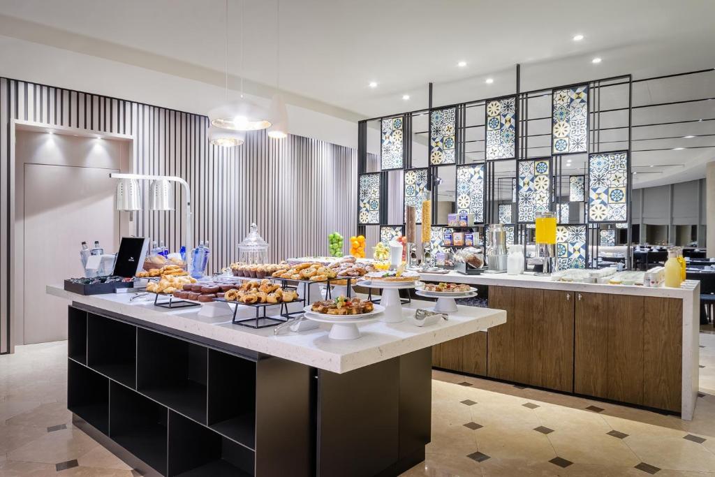 a buffet in a hotel with food on a counter at Eurostars Torre Sevilla in Seville