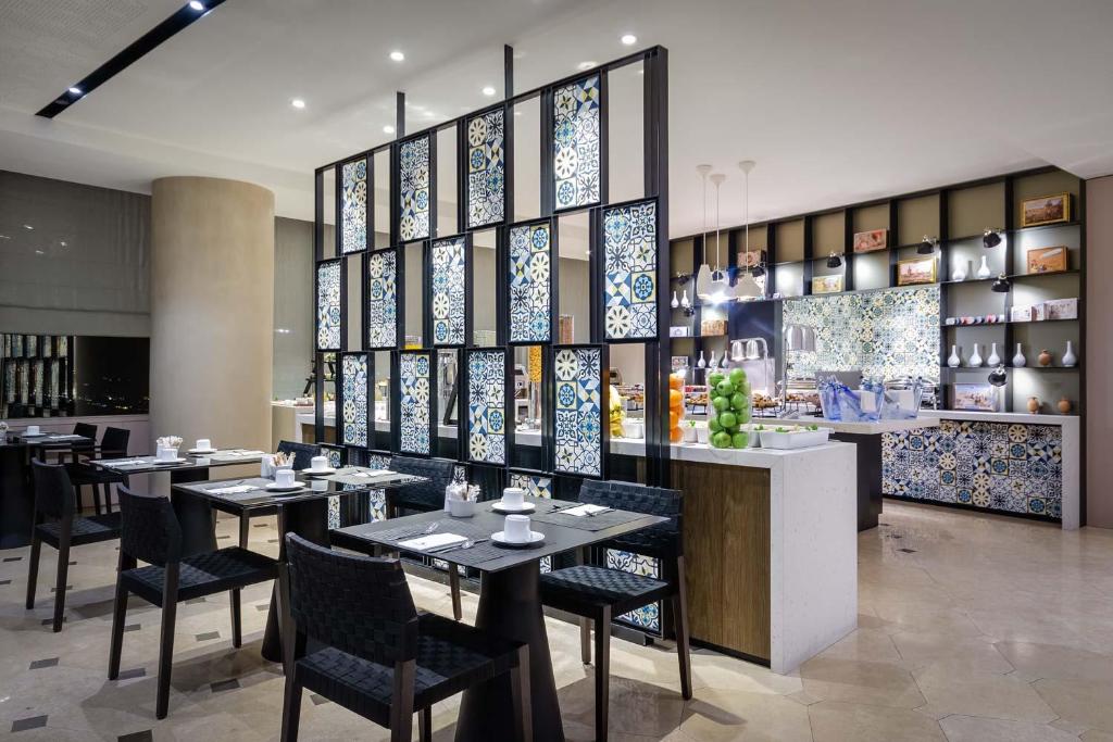 a restaurant with tables and chairs in a room at Eurostars Torre Sevilla in Seville