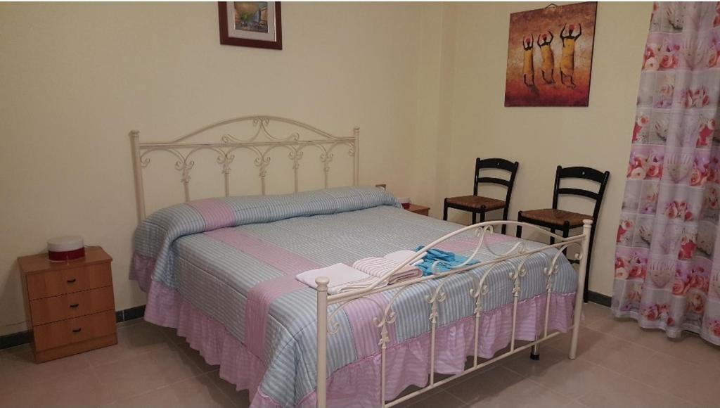a bedroom with a bed and two chairs at Casa Sibarys 20 mt dalla Stazione piano terra in Sibari