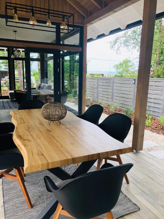 a wooden table and chairs in a living room at Mókus Apartmanház in Balatonszárszó