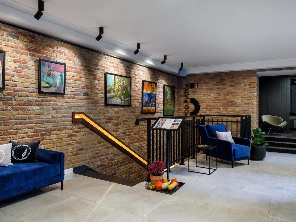 a living room with a brick wall and blue furniture at Hotel Logos Kraków in Krakow
