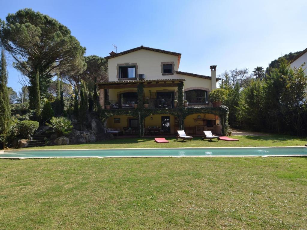 a house with a swimming pool in front of a house at Villa swing in Santa Cristina d'Aro