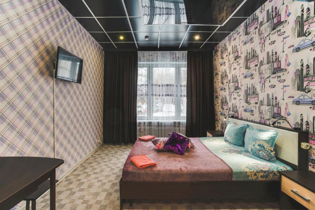 モスクワにあるHotel Ladomirの壁紙のベッドルーム1室(ベッド1台付)
