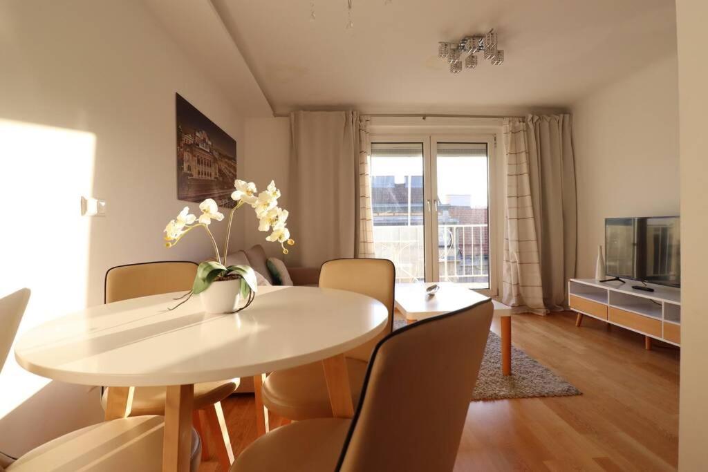 a dining room with a white table and chairs at Brilliant View: Balcony Home, Modern, Stylish and newly Renovated in Vienna