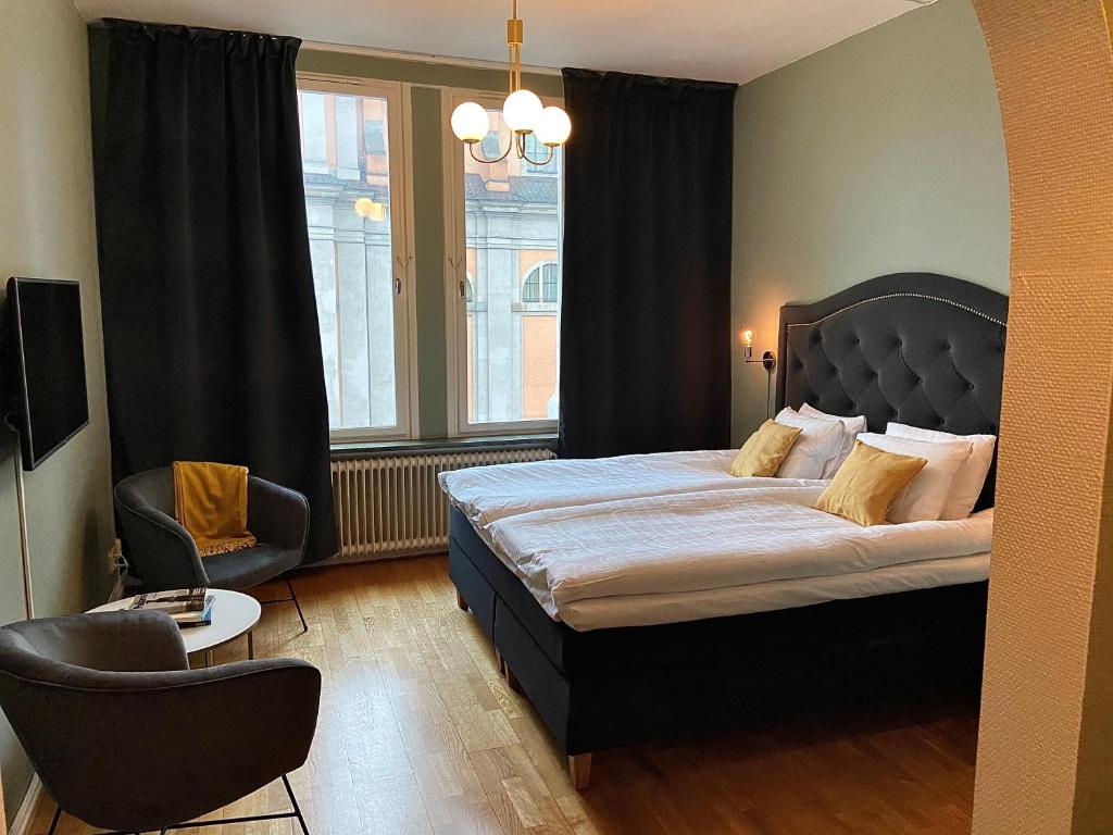 a bedroom with a bed and a chair and a window at First Hotel Statt in Karlskrona