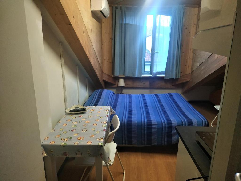 トリノにあるMansarda Arelのベッドとテーブル付きの小さな部屋