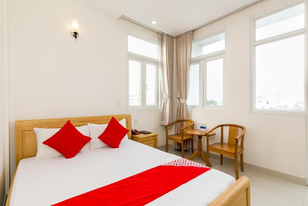 a bedroom with a large bed with red pillows at Ph&uacute; Ho&agrave;ng Nam Hotel in Ho Chi Minh City