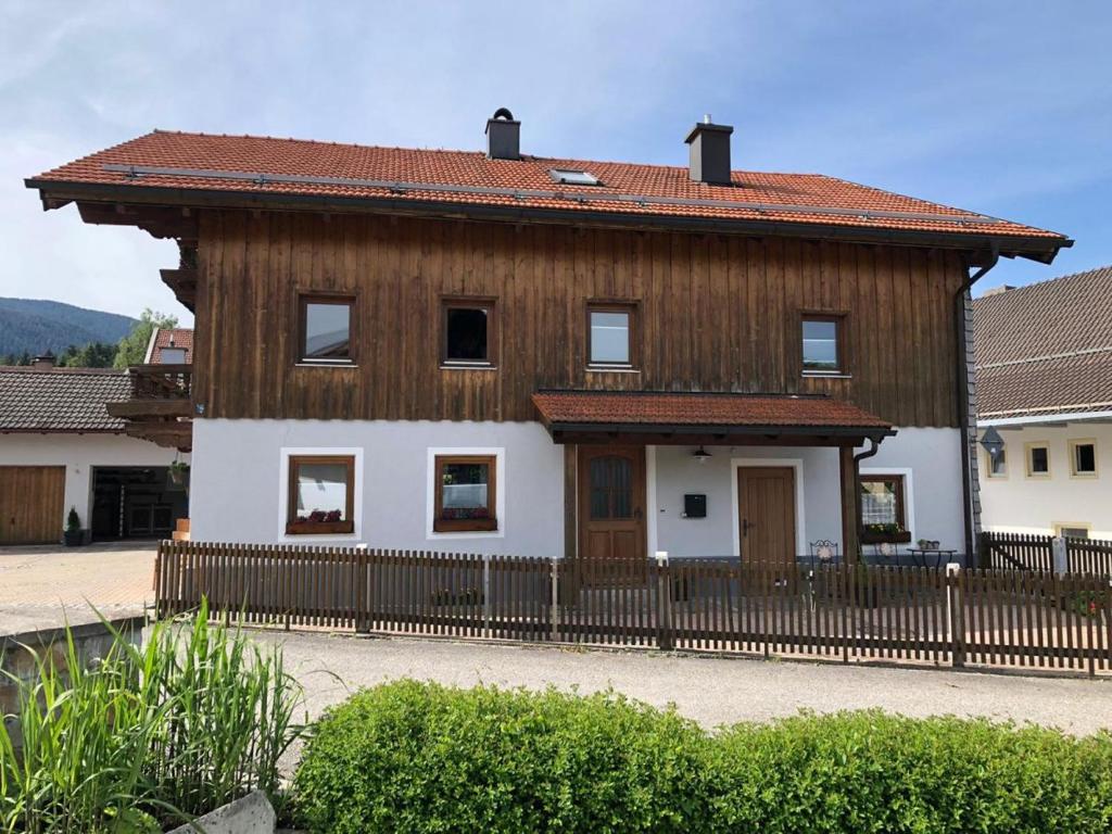 una casa de madera con una valla delante en Monteurzimmer am Teisenberg en Neukirchen am Teisenberg