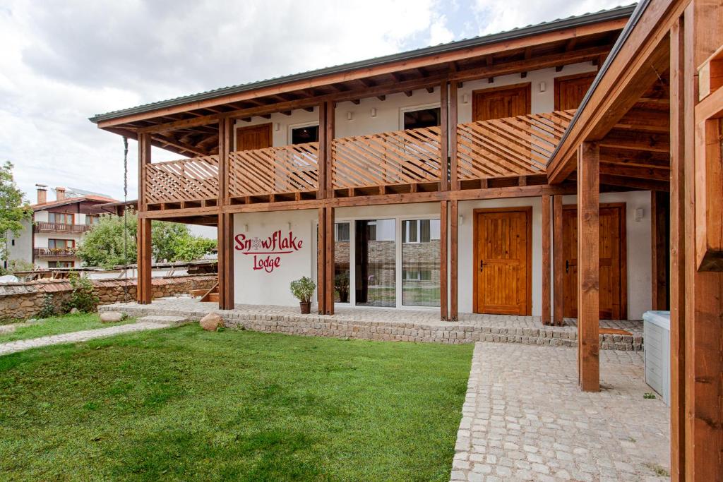 una casa con un gran patio delante de ella en Къщи за гости Сноуфлейк Snowflake Chalet and Snowflake Lodge, en Bansko