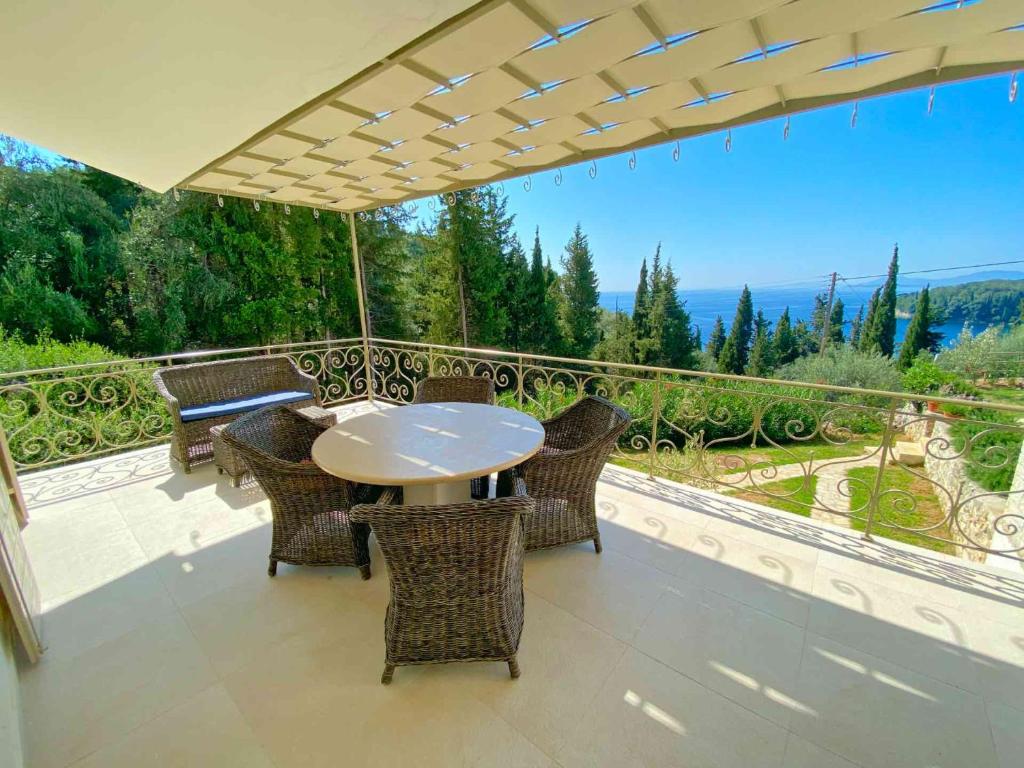 a patio with a table and chairs on a balcony at Paleopetres K-Five - Premium Double Suite - Kalami - in Kalami
