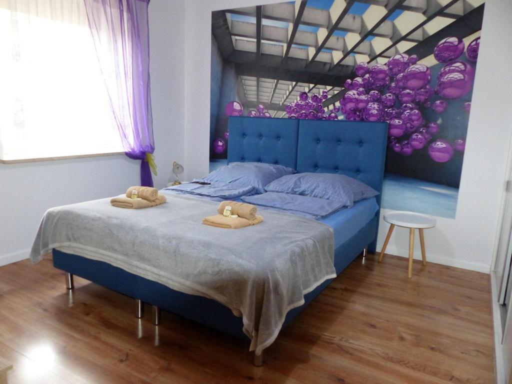 a bedroom with a blue bed with two towels on it at Apartament Kraszewskiego in Bytom