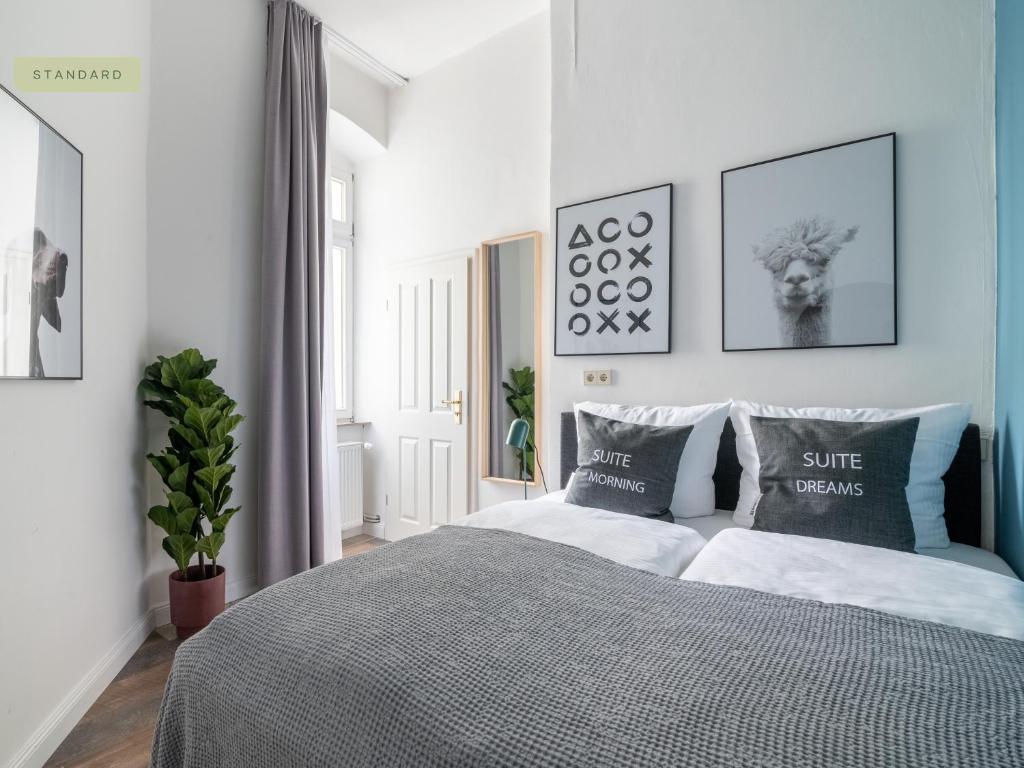 a bedroom with a bed and some pictures on the wall at Apartments Berlin Bornimer Straße in Berlin