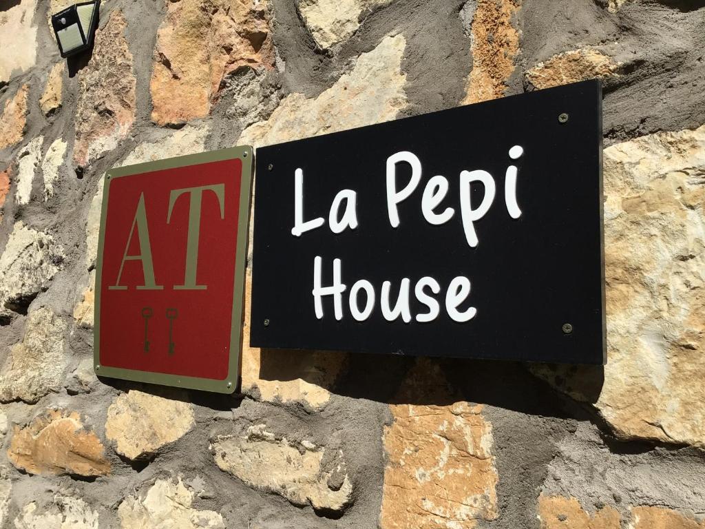 ein Schild für ein La-la-Peep-Haus an einer Steinmauer in der Unterkunft La Pepi house in Arcones