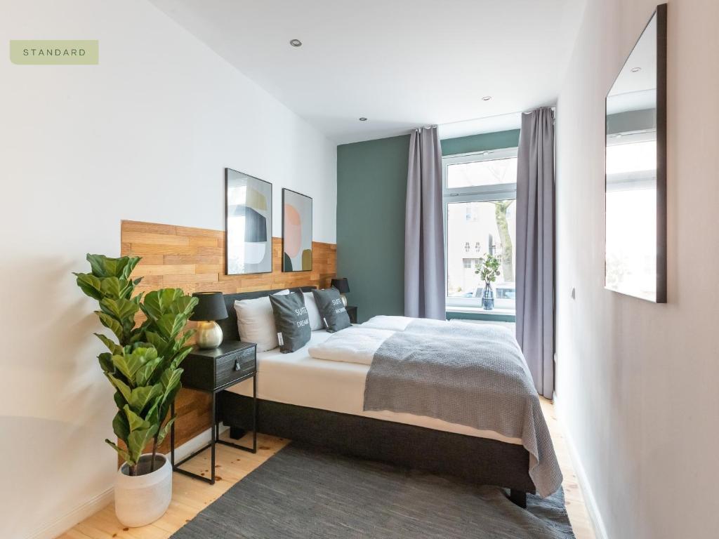 ein Schlafzimmer mit einem Bett und einem großen Fenster in der Unterkunft Apartments Berlin Aroser Allee in Berlin