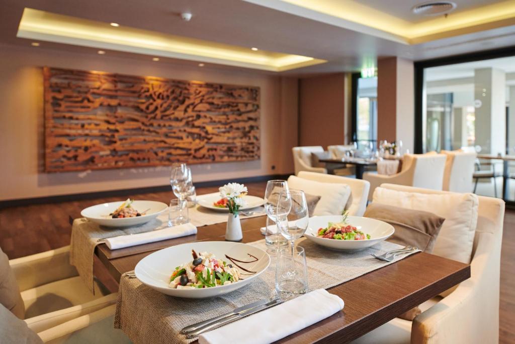 a dining room with a table with plates of food at Hotel Parentium Plava Laguna in Poreč