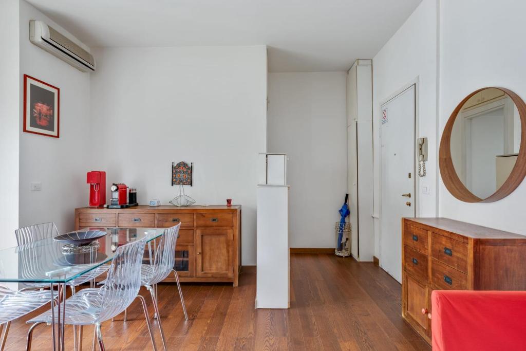 a dining room with a glass table and a mirror at Easylife - Strategic apt in Washington in Milan