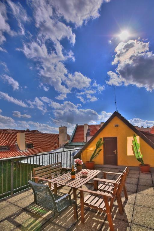 patio z drewnianym stołem i krzesłami na dachu w obiekcie Ericsson Palace w Pradze
