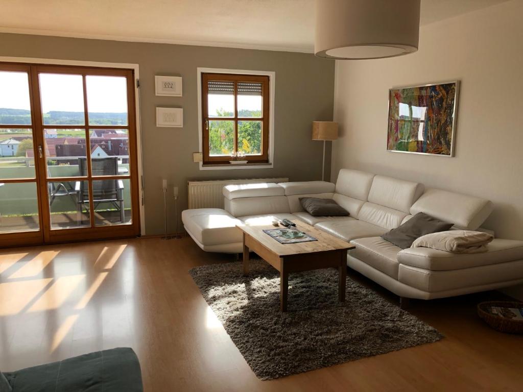 uma sala de estar com um sofá branco e uma mesa em Ferienwohnungen Sonnenseite Brombachsee em Absberg