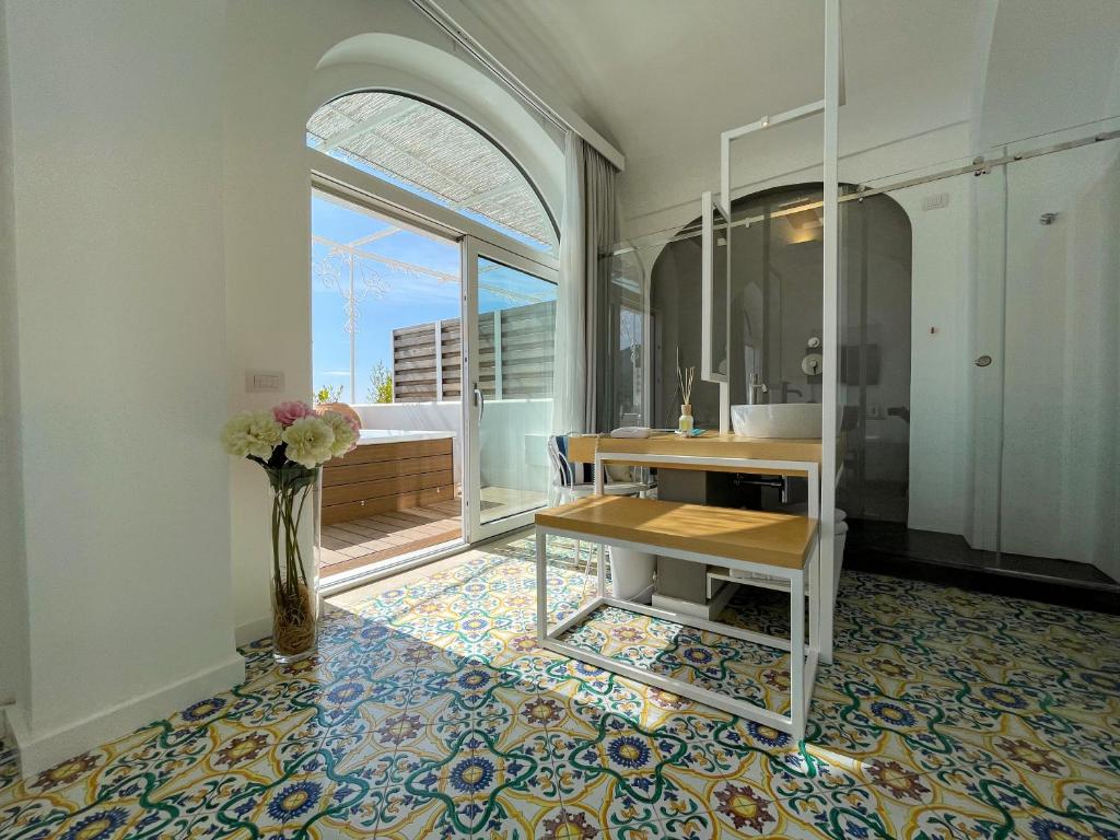 a bathroom with a sink and a vase of flowers at Hotel Montemare in Positano