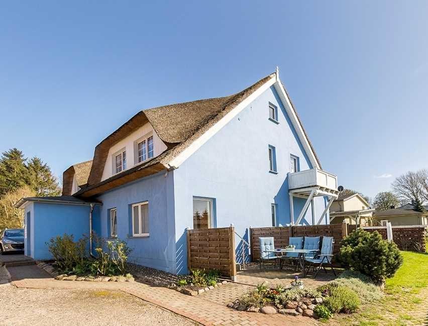 a white and blue house with a table and chairs at Mohnblume in Zirkow