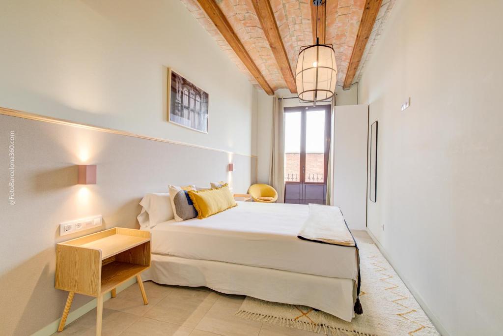 a bedroom with a large bed and a table at CATERINA House Port Vell in Barcelona