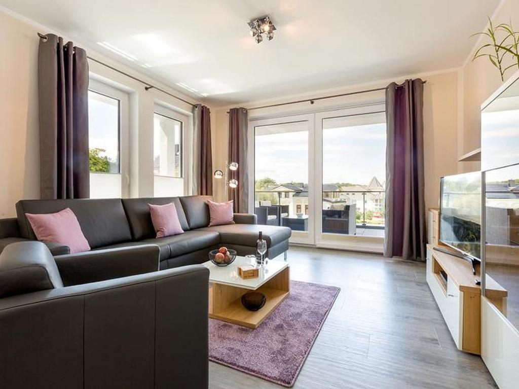 - un salon avec un canapé et un aquarium dans l'établissement Residenz Seeterrassen Appartment Nr. 1, à Binz