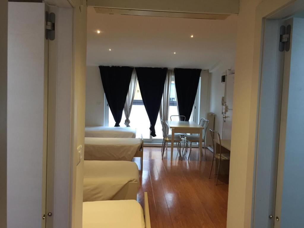 Zimmer mit Betten, einem Tisch und einem Fenster in der Unterkunft M14 Duomo Apartments in Padua