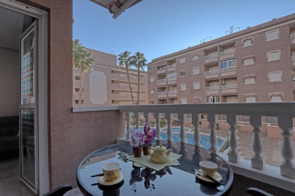 a glass table on a balcony with a view of a building at 042 - Las Marismas I - 002 comfortHOLIDAYS in Santa Pola
