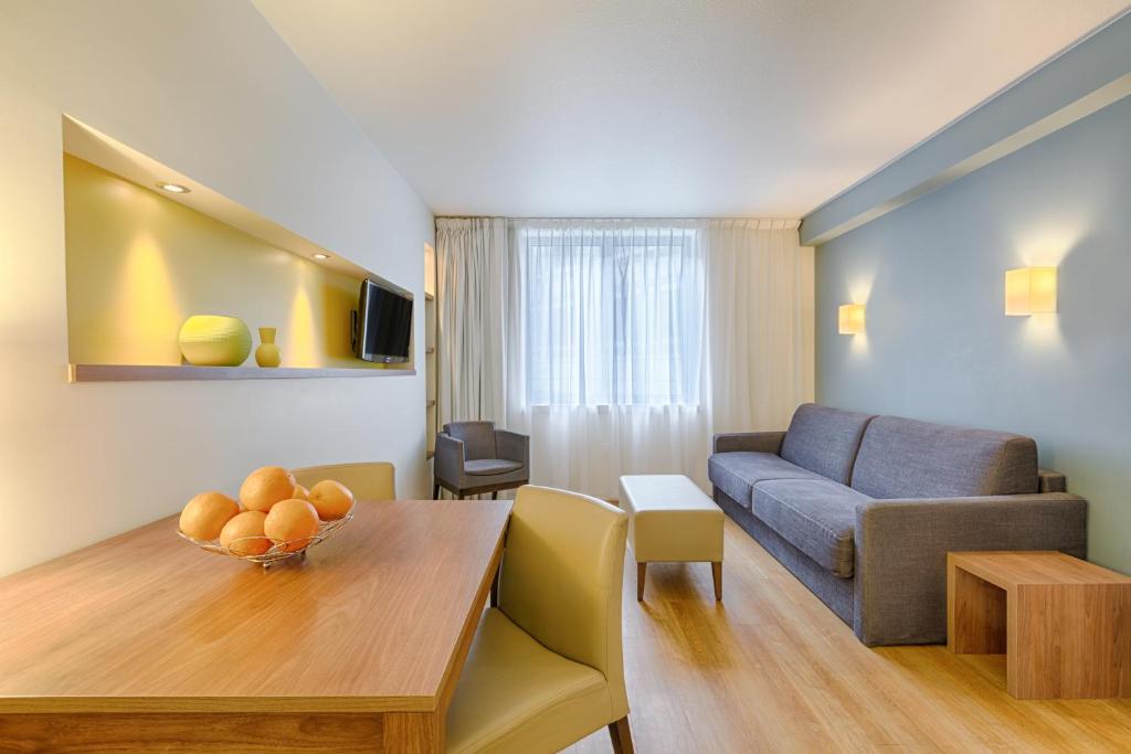 a living room with a table and a couch at Citadines Place d'Italie Paris in Paris