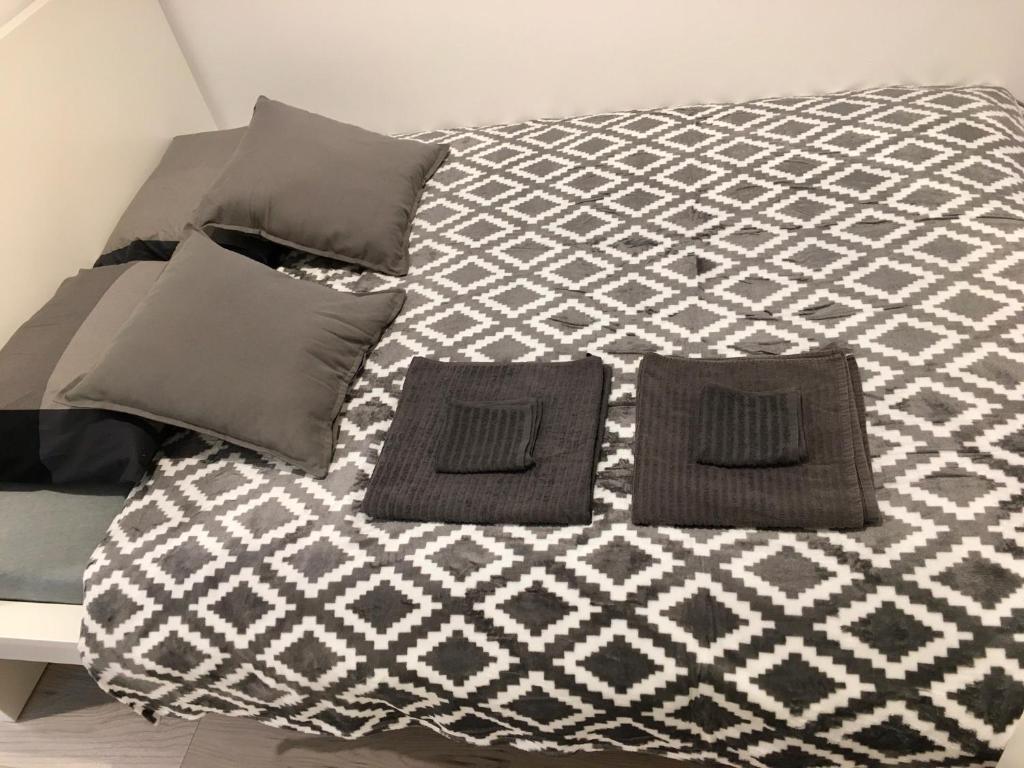 a bed with two pillows on top of it at Apartament Fibra Bounty in Rybnik
