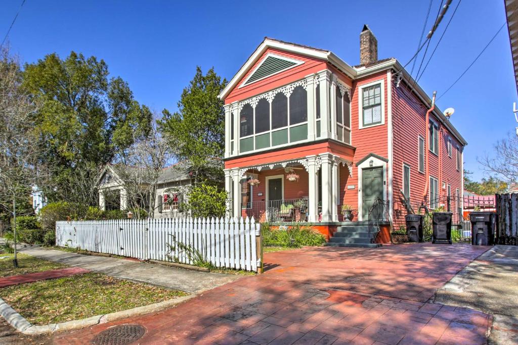 une maison rouge avec une clôture blanche devant elle dans l'établissement Vibrant NOLA Retreat about 2 Miles to Bourbon Street, à La Nouvelle-Orléans