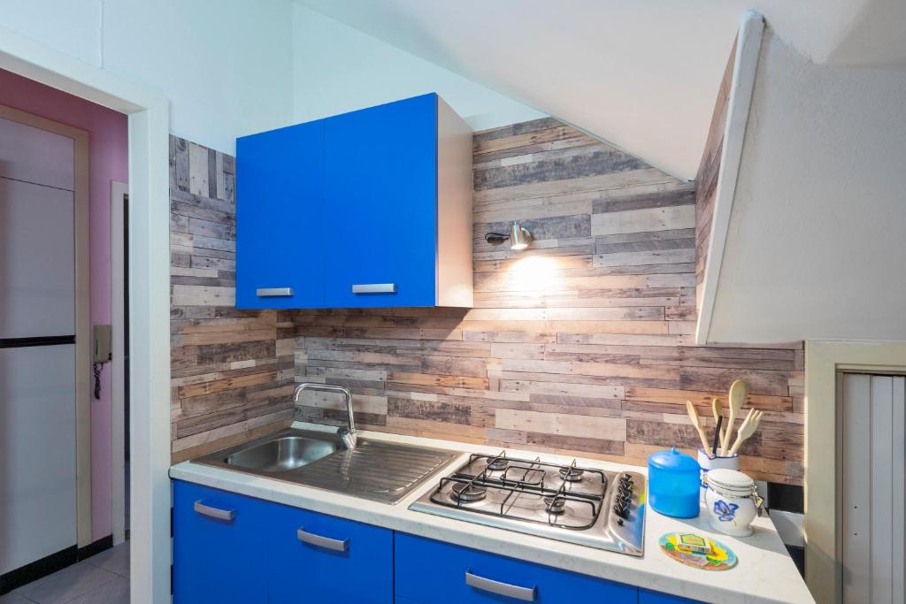una cucina con piano cottura e armadio blu di Intera casa con 3 camere 2 bagni giardino wifi parcheggio a Tuglie