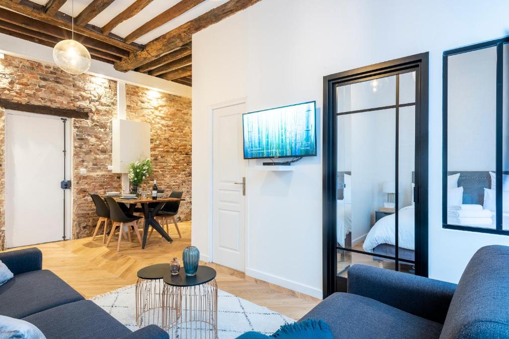 a living room with a blue couch and a table at GemBnB Luxury Apartments - Residence Timbaud Paris-Oberkampf in Paris