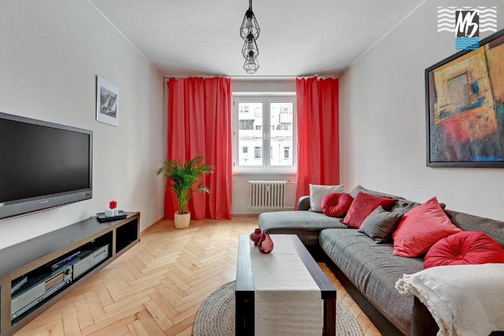 a living room with a couch and a flat screen tv at MS Apartments Centrum Gdyni I in Gdynia
