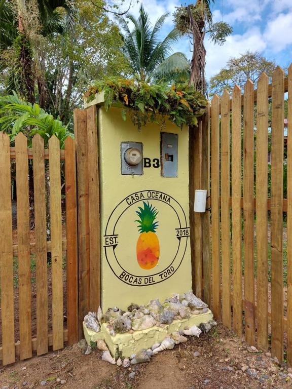 a sign with a pineapple on it in front of a fence at Casa Oceana Bed & Breakfast in Bocas Town