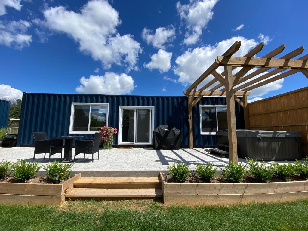a small house with a patio and a wooden pergola at Inner Joy Getaways in Elora