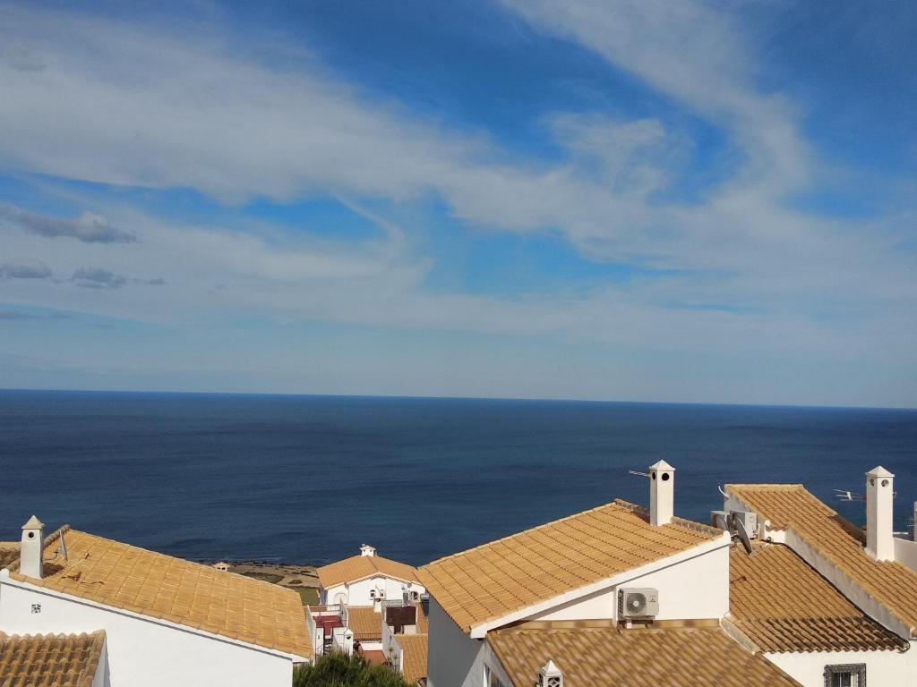 a view of roofs of houses and the ocean at Bungalow Mediterraneo in Santa Pola