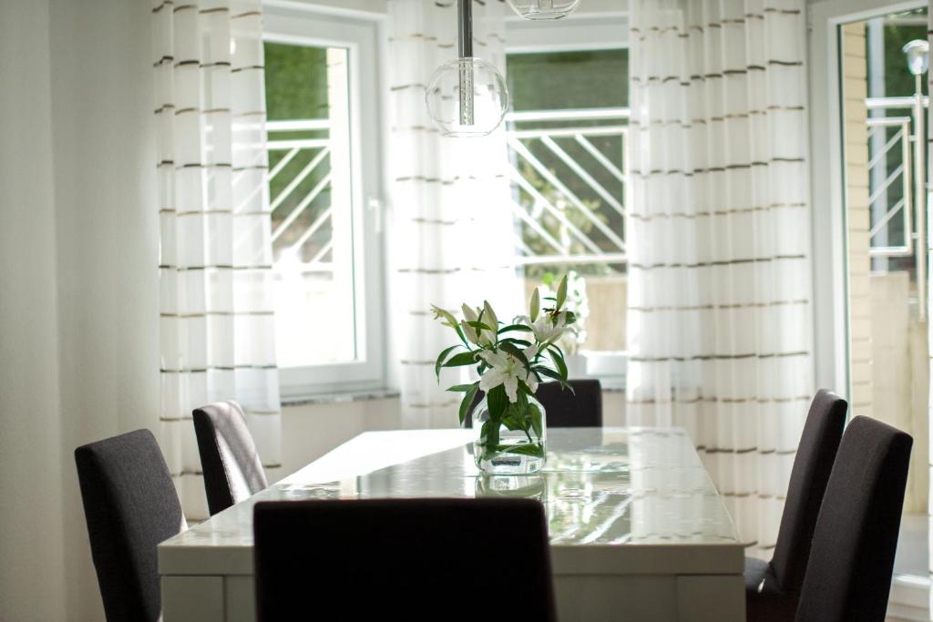 a dining room table with chairs and a vase of flowers at Ferienwohnung Donau in Balingen